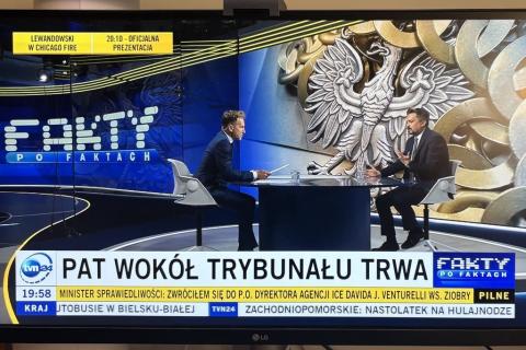 dwie osoby siedzą w studiu telewizyjnym 
