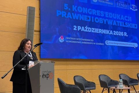 Beata Tarnawska-Domalewska wypowiada się stojąc przy podium w sali konferencyjnej