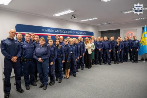 Kilkadziesiąt osób w mundurach policyjnych pozuje na stojąco do wspólnego zdjęcia z Rzecznik Praw Obywatelskich