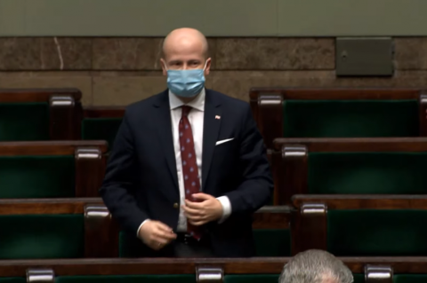 Osoba stoi w sali plenarnej Sejmu 