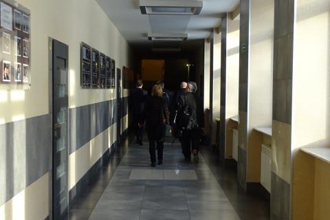 zdjęcie: tyłem widać kilka osób idących korytarzem