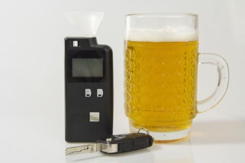 Kufel piwa, aparat do pomiaru alkoholu w organiźmie i kluczyki do samochodu