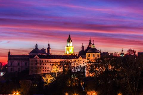 Wielobarwna fotografia zamku w Lublinie nad miastem o zachodzie słońca