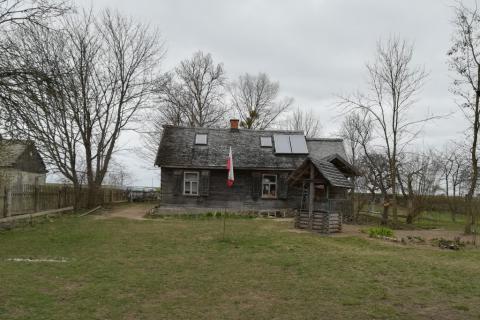 Drewinany domek i białoczerowna flaga