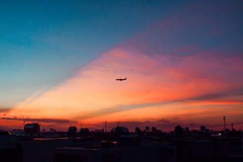 Samolot nad lotniskiem w zachodzącym słońcu