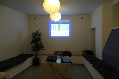 Zdjęcie: pusta sala, na ścinie prezentacja z napisem Małopolskie Stowarzyszenie Probacja