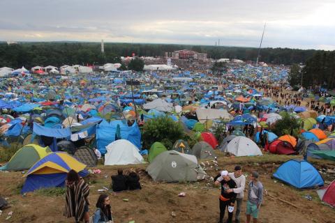 zdjęcie: wielkie pole namiotowe, w tle duża scena muzyczna