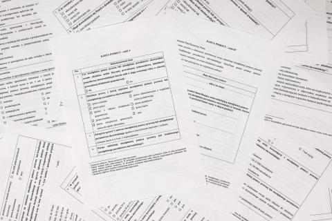 Plik kartek ze szczegółowym formularzem rozłożonych na płaskiej powierzchni